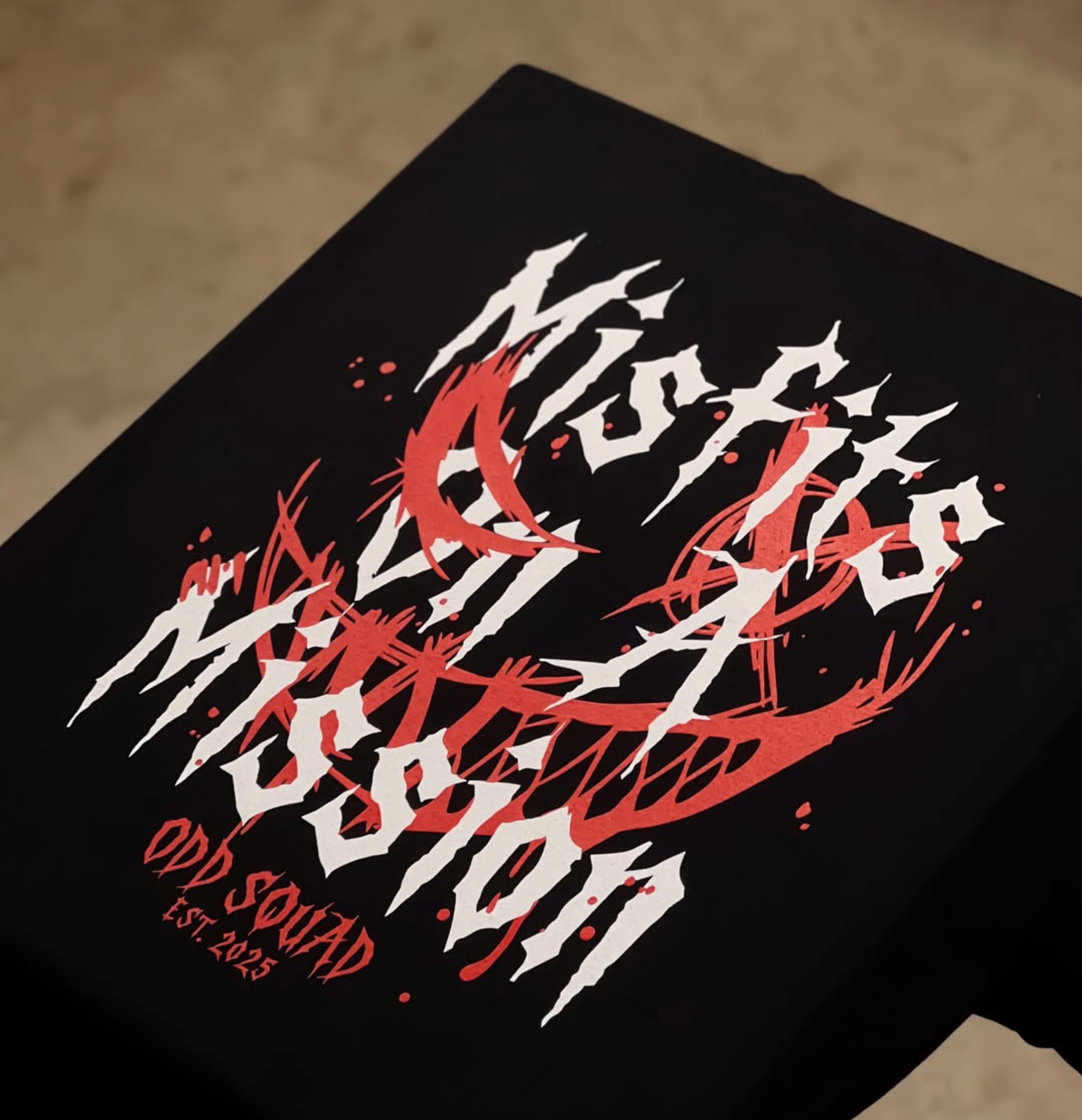 Red and white Odd Squad graphic printed on a black garment